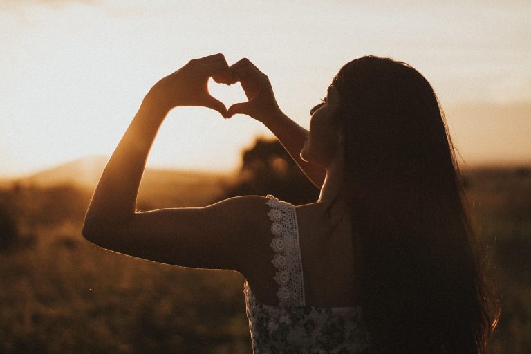 Donna che pratica un rituale spirituale quotidiano, mano sul cuore, momento di connessione interiore”